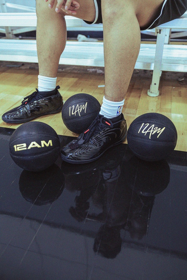 12AM weighted basketballs arranged around a player’s shoes beside the court